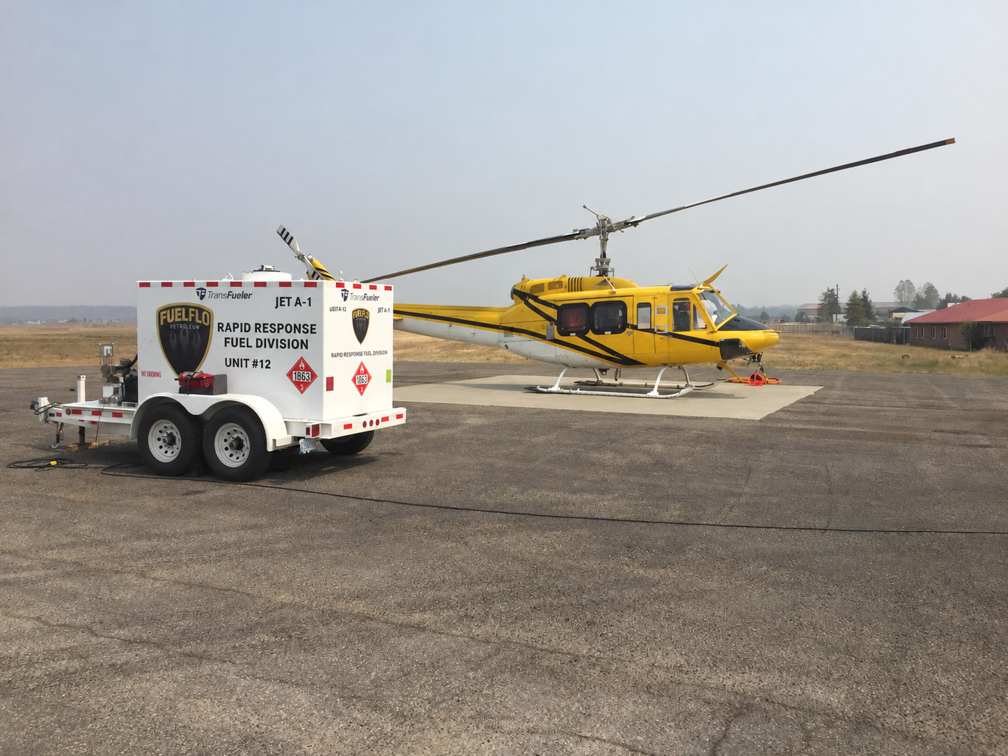 Fuel Flo rapid response fuel trailer beside a yellow helicopter