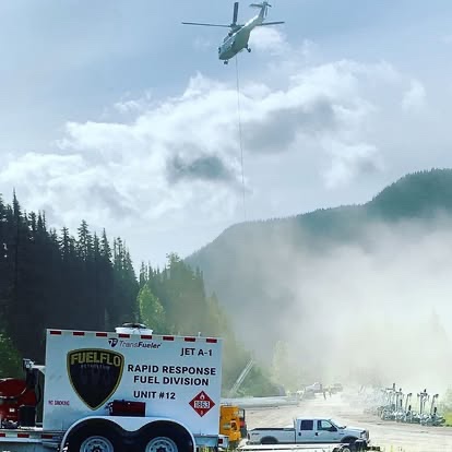 Fuel Flo rapid-response JET A-1 fuel trailer with a helicopter lowering a line over a mountain staging area