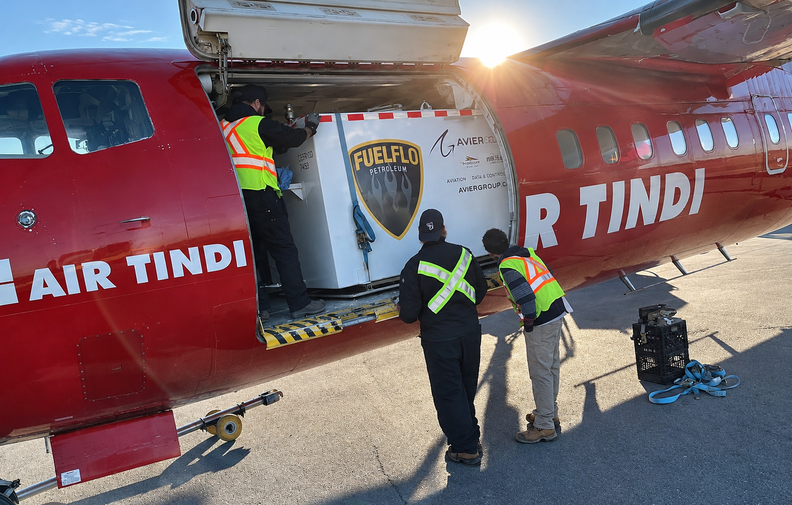 Crew loading a Fuel Flo branded tank into an Air Tindi aircraft