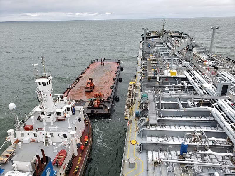 Tug and barge alongside a tanker during marine logistics operations